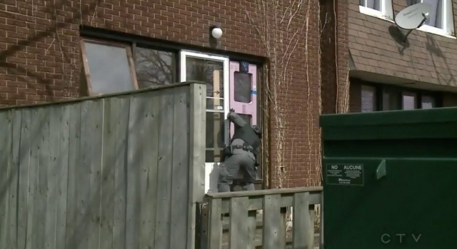 An Ottawa Police Services tactical officer is seen preparing a Heron Gate Village townhouse for a bombing exercise.